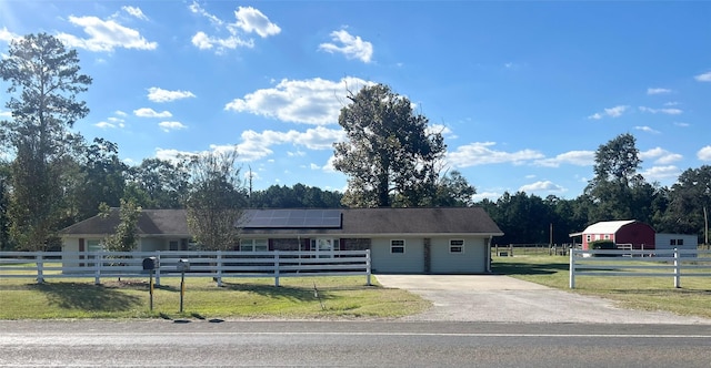 ranch-style house with a front lawn and solar panels