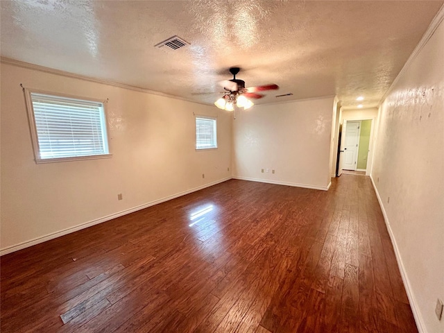 empty room featuring ceiling fan, a textured ceiling, dark hardwood / wood-style floors, and crown molding