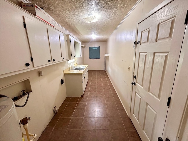 washroom featuring hookup for an electric dryer, hookup for a washing machine, a textured ceiling, cabinets, and sink