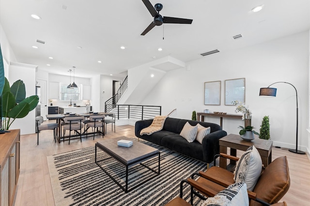 living room featuring ceiling fan and light hardwood / wood-style floors