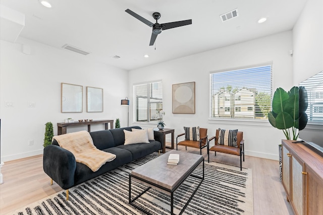 living room featuring a wealth of natural light, ceiling fan, and light hardwood / wood-style flooring