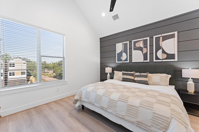 bedroom with high vaulted ceiling, ceiling fan, and light wood-type flooring