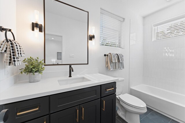 full bathroom featuring vanity, tiled shower / bath, tile patterned floors, and toilet