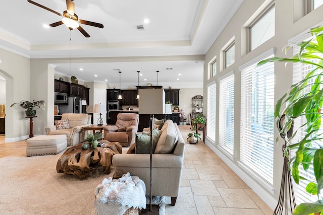 living room with ceiling fan and crown molding