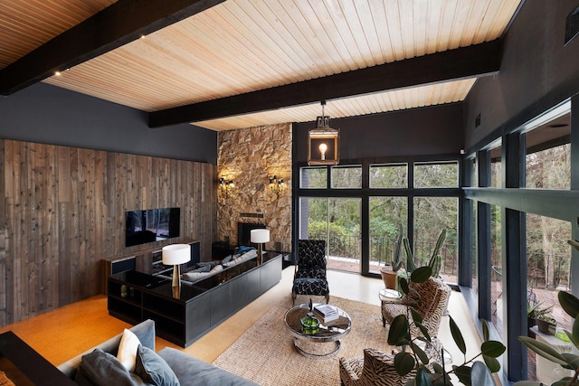 living room with wooden ceiling, beam ceiling, wood walls, and a stone fireplace