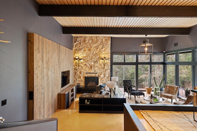 living room featuring a high ceiling, wood ceiling, beamed ceiling, and a stone fireplace