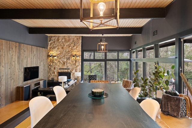 dining room with a towering ceiling, beamed ceiling, and a fireplace