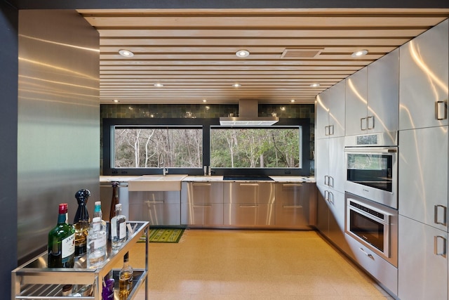 kitchen with sink, black cooktop, wall chimney exhaust hood, and oven