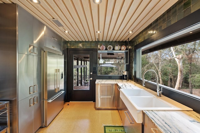 kitchen featuring built in refrigerator and sink