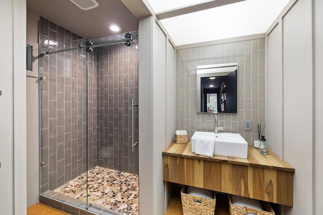 bathroom featuring a shower with shower door and vanity