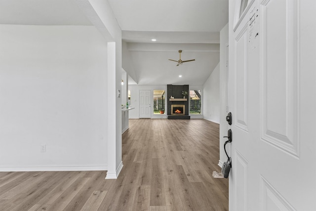 entrance foyer with a brick fireplace, light hardwood / wood-style floors, high vaulted ceiling, and ceiling fan