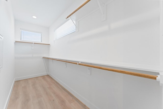 walk in closet with light hardwood / wood-style flooring