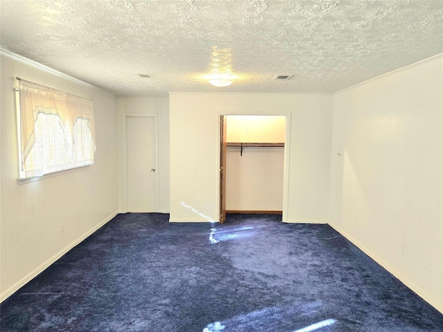 unfurnished bedroom with a textured ceiling, a closet, and dark colored carpet