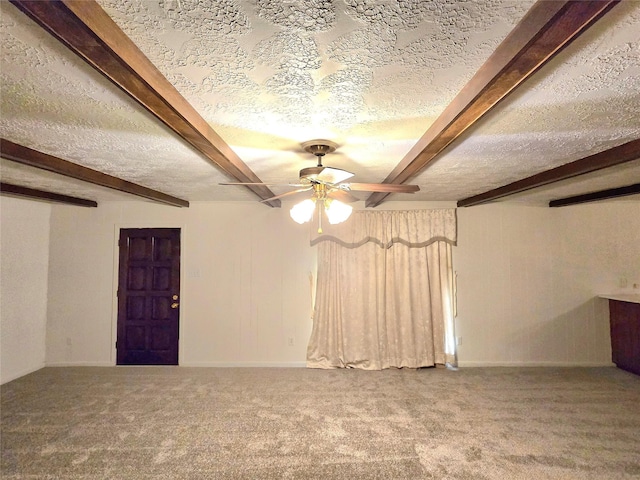 unfurnished room with beam ceiling, ceiling fan, carpet, and a textured ceiling