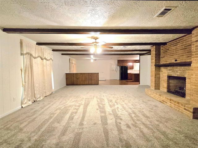 unfurnished living room featuring ceiling fan, carpet floors, a fireplace, a textured ceiling, and beam ceiling