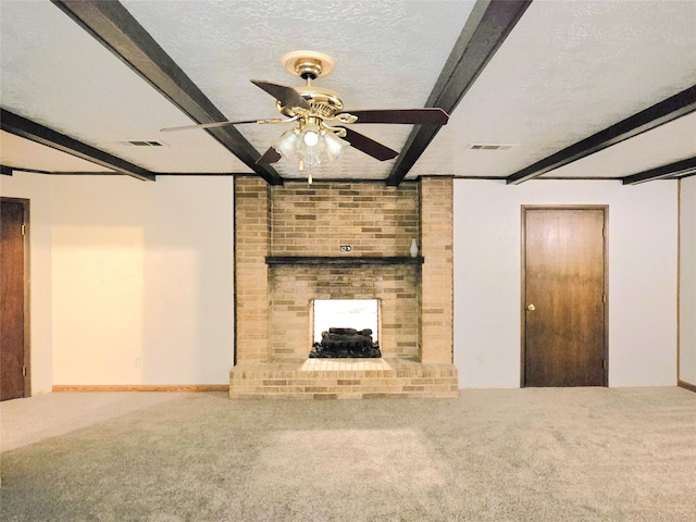 unfurnished living room with ceiling fan, carpet, a fireplace, beamed ceiling, and a textured ceiling