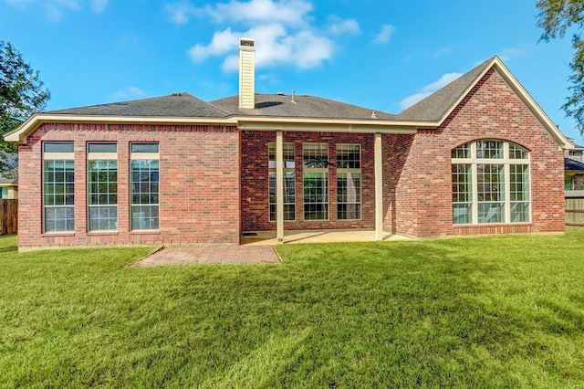 back of house featuring a lawn and a patio