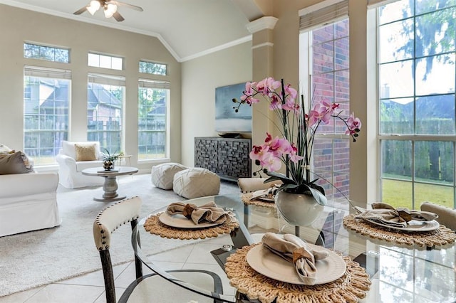 interior space with ceiling fan, vaulted ceiling, tile patterned floors, crown molding, and ornate columns