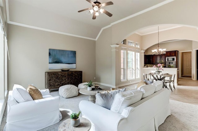 living room featuring ceiling fan with notable chandelier, light tile patterned floors, ornamental molding, and vaulted ceiling