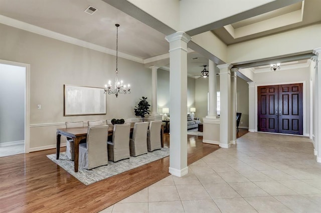 dining area with light tile patterned floors, ceiling fan with notable chandelier, and ornamental molding