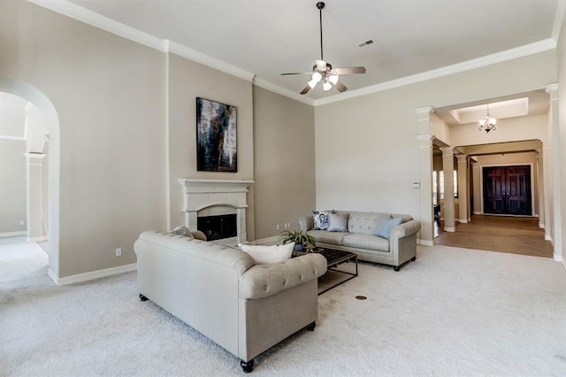 living room with light colored carpet, ceiling fan with notable chandelier, and ornamental molding