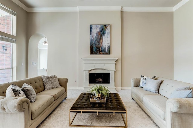 carpeted living room with ceiling fan and crown molding