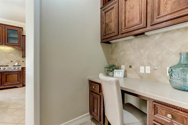 home office with built in desk, light tile patterned floors, and crown molding