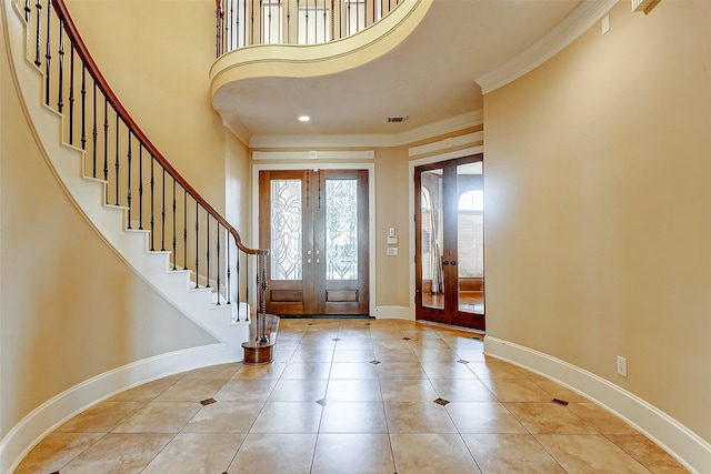 tiled foyer entrance with ornamental molding and french doors