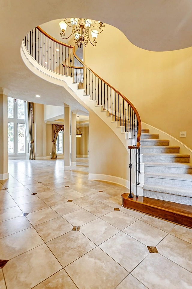 staircase featuring a high ceiling, tile patterned floors, and a chandelier