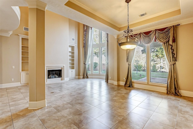 unfurnished dining area featuring built in shelves, a tray ceiling, crown molding, and light tile patterned flooring