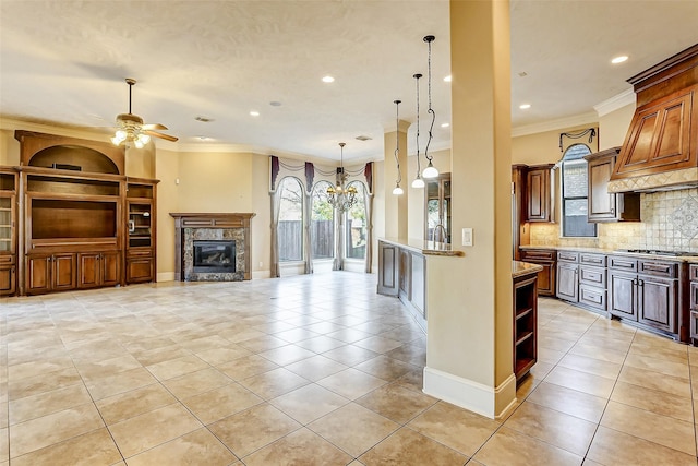 kitchen featuring ceiling fan, backsplash, stainless steel gas stovetop, and ornamental molding