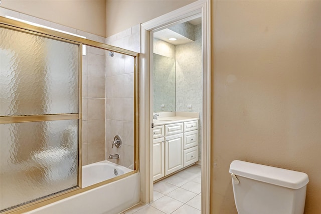 full bathroom with combined bath / shower with glass door, vanity, tile patterned floors, and toilet