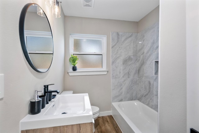 full bathroom with toilet, washtub / shower combination, sink, and hardwood / wood-style floors