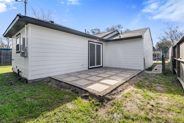 rear view of house featuring a lawn and a patio