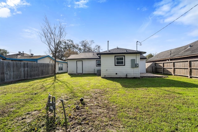 back of house featuring central AC unit and a yard