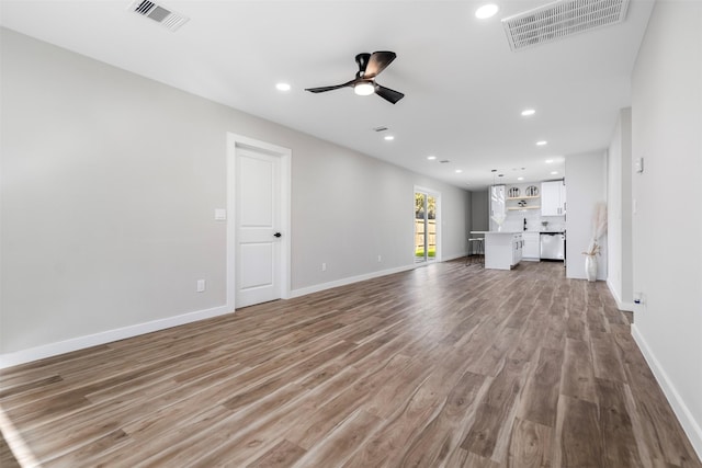 unfurnished living room with light wood-type flooring and ceiling fan