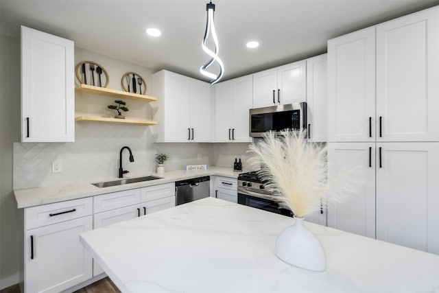 kitchen with white cabinetry, sink, backsplash, and stainless steel appliances