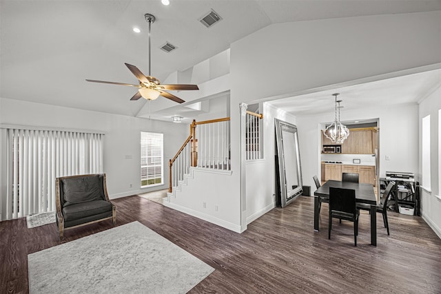 living room featuring ceiling fan with notable chandelier, dark hardwood / wood-style floors, and lofted ceiling