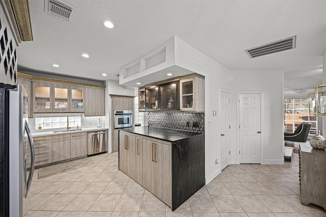 kitchen featuring decorative backsplash, a textured ceiling, stainless steel appliances, and light tile patterned flooring