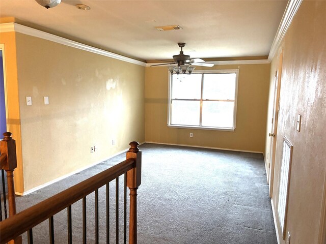 empty room with crown molding, ceiling fan, and carpet