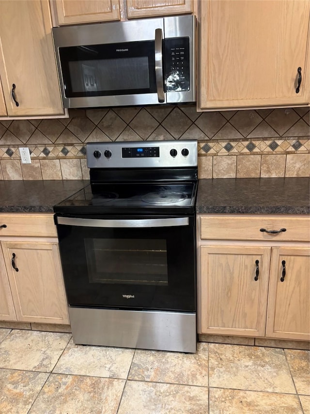 kitchen featuring appliances with stainless steel finishes, light brown cabinets, and decorative backsplash