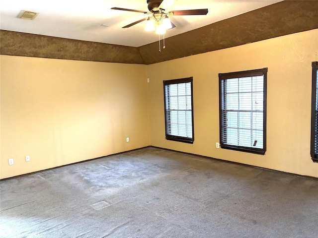 empty room with vaulted ceiling, ceiling fan, and carpet