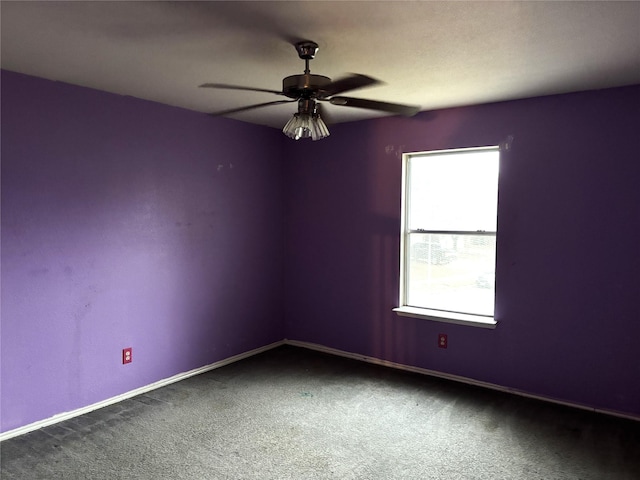 carpeted spare room featuring ceiling fan