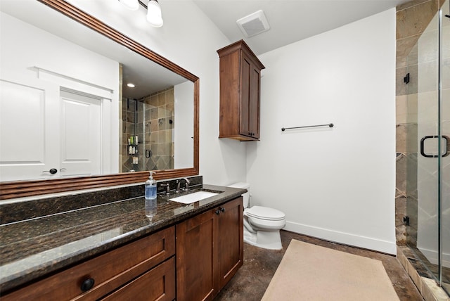 bathroom with a shower with shower door, vanity, and toilet