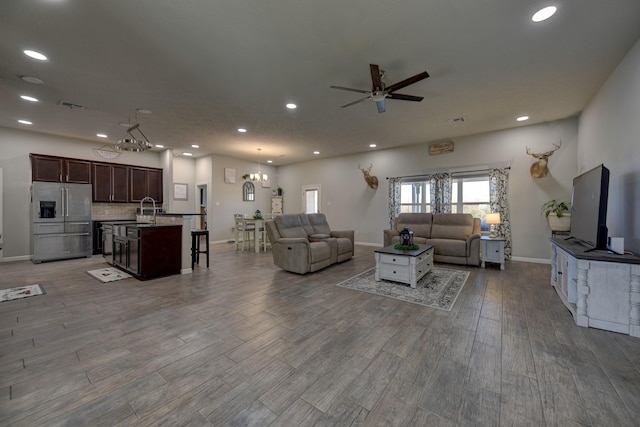 living room with sink and ceiling fan with notable chandelier