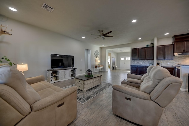 living room with ceiling fan and light wood-type flooring