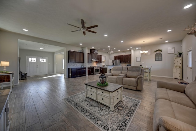 living room featuring ceiling fan with notable chandelier