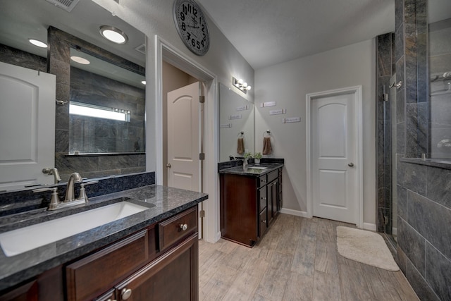 bathroom featuring tiled shower and vanity