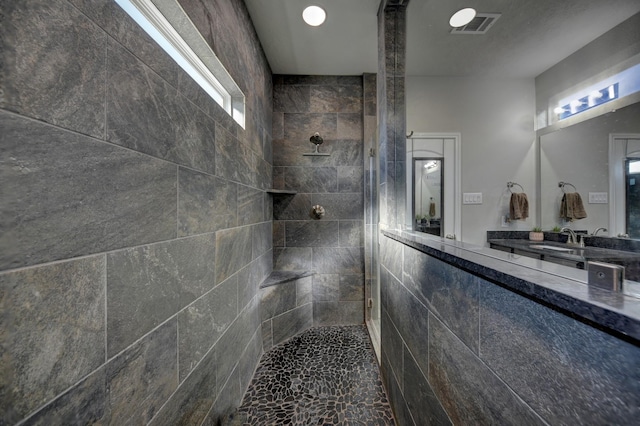 bathroom featuring a tile shower and sink