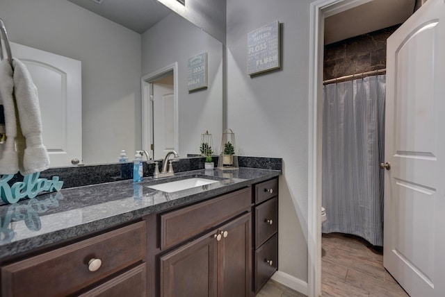 bathroom with hardwood / wood-style flooring, toilet, vanity, and a shower with curtain